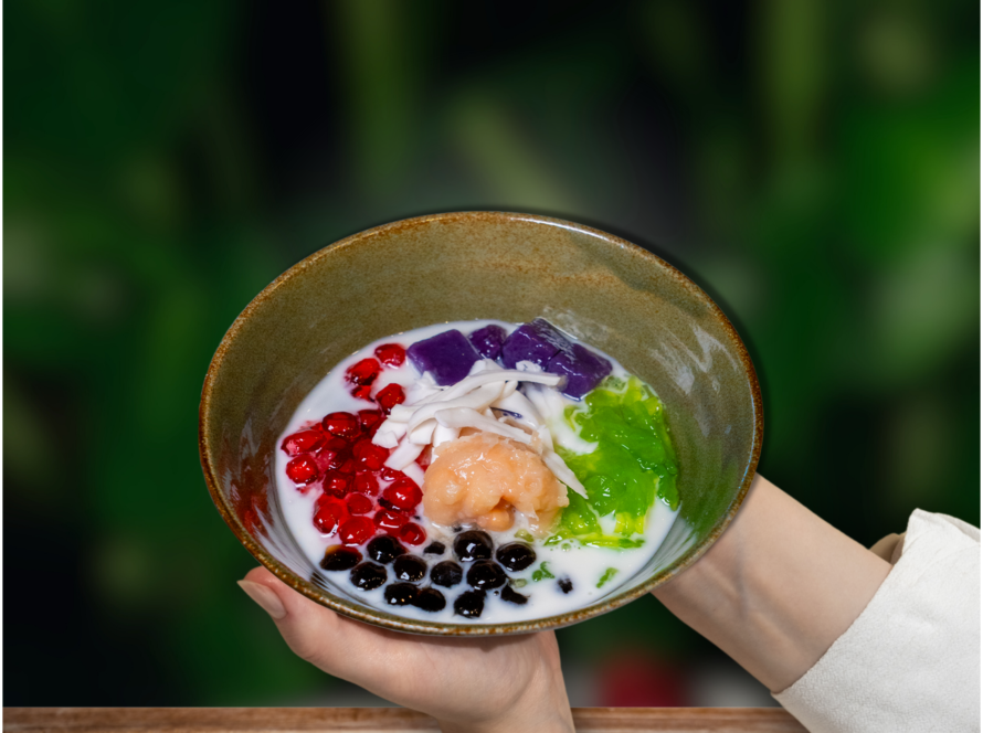 A person holds a bowl of food, showcasing a delicious meal from Hoi An Imperial.